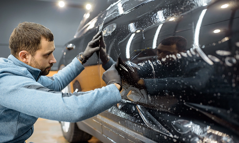 An expert applies ceramic coating to a door panel