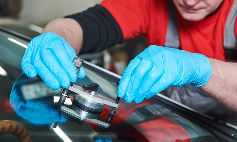 Windshield repair in process with glass tools
