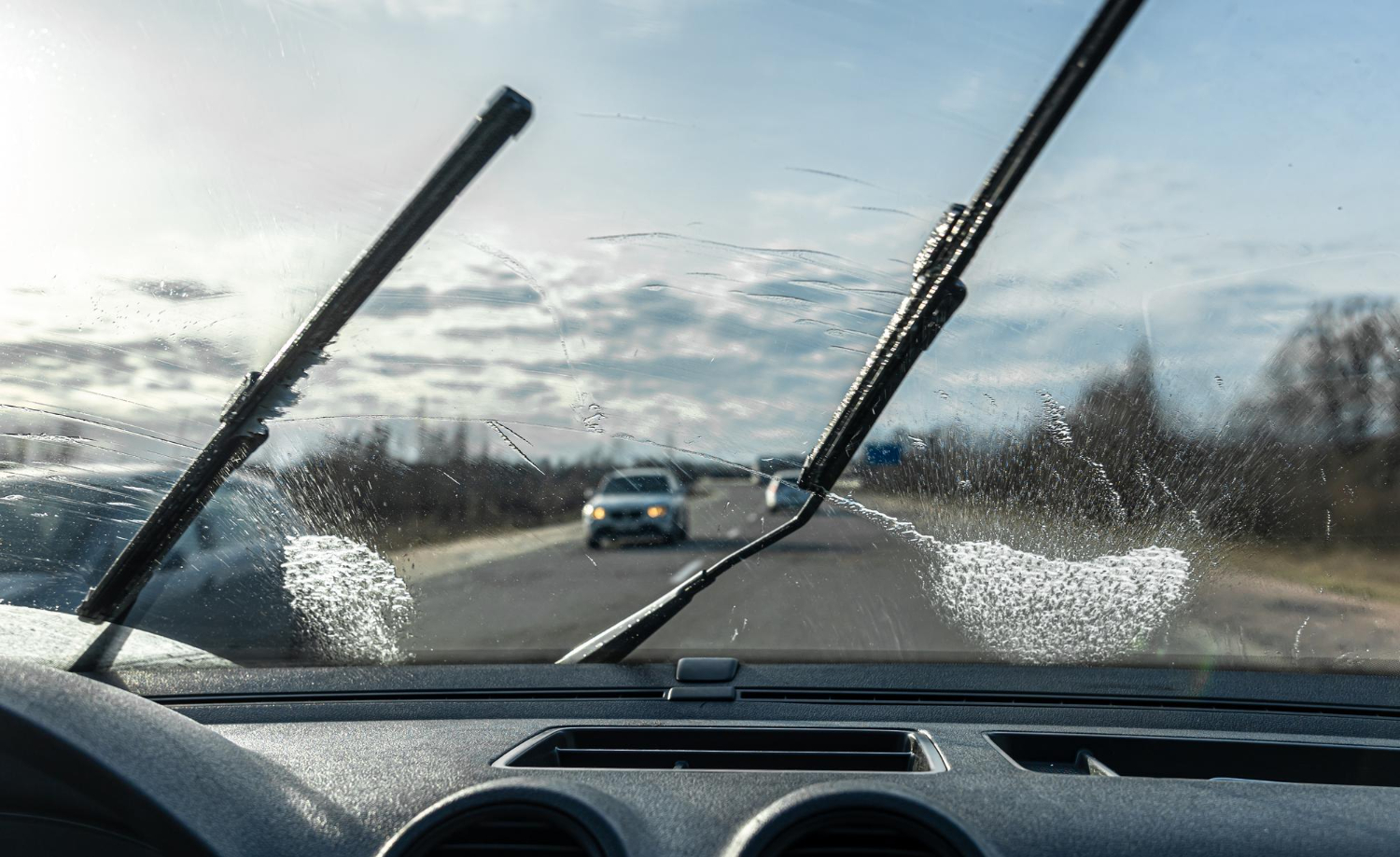 Car wipers clean windshields when driving in sunny weather